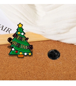 Detail of Christmas tree enamel brooch with Merry Christmas text and butterfly clutch