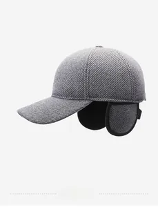 Detail of grey twill wool winter baseball cap with plush earflaps and metal logo