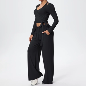 Détail d'un ensemble de yoga noir avec haut cache-cœur à manches longues et pantalon
