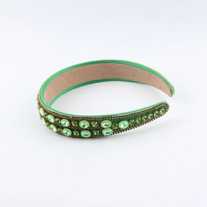 Detail of green Baroque headband featuring faceted emerald crystals and golden settings
