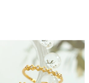 Détail de la bague en acier plaqué or 18 carats avec zircons sur anneau ondulé chic