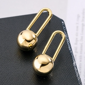 Close-up of golden geometric sphere earrings with a polished metallic finish and sleek hooks