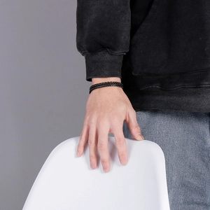 Lifestyle shot of a man wearing a double-layer black punk style braided steel bracelet
