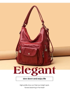 Detail view of red PU leather bag featuring multiple zipper pockets and silver hardware