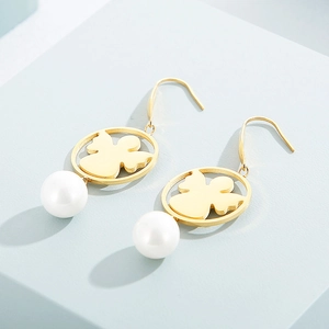 Gold angel drop earrings with white pearl accents on minimalist light blue background