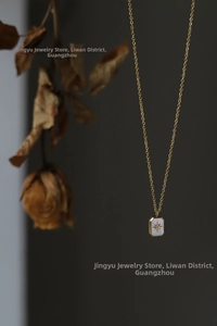 Detail of 18K gold star pendant with white mother-of-pearl inlay and zircon stone