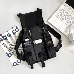 Detailed view of black nylon tactical chest bag with MOLLE system on a white desk