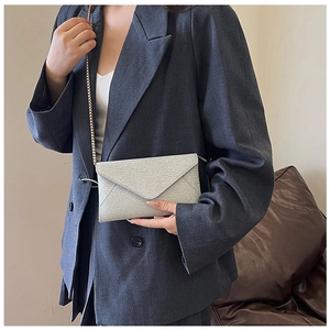Schicke silberne Glitzer-Umschlagtasche mit Metallkette, präsentiert von einem Model