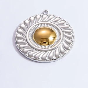 Macro shot of circular dual-tone metal pendant with spiral texture and gold center