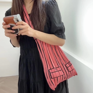 Pink pleated knit shoulder bag with black stripes and small decorative pockets