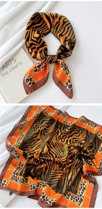 Close-up of animal print silk scarf with golden chains and stylish leopard patterns
