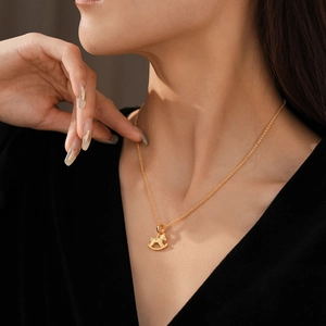 Dettaglio della collana con ciondolo a cavallo a dondolo placcata oro 18K indossata