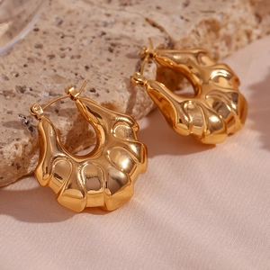 Polished 18K gold plated chunky hoop earrings with wavy texture on stone background