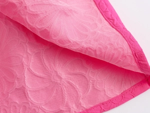 Close-up detail of pink mesh fabric texture and ruffle edge on a mini dress