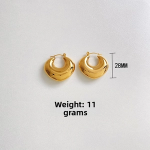 Detail shot of chunky gold U-shaped earrings with 28mm height and 11g weight specs