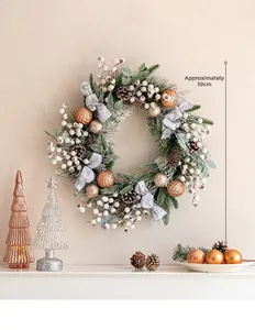 Close-up of 50cm Christmas wreath with gold baubles, pine cones, and blue ribbon on a wall