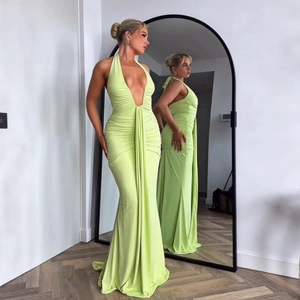 Detail of lime green halter neck dress with pleated waist and elegant fishtail hem