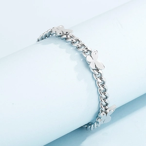 Detailed view of silver butterfly cuban link bracelet with sparkling zircon stones