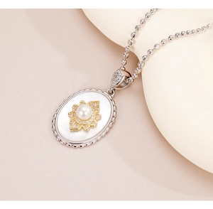 Close-up of 925 silver necklace with oval mother of pearl pendant and gold flower motif