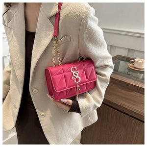 Detail of rose red quilted crossbody bag with gold SS lock and metallic fringe charm