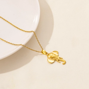 Detail of a golden elephant pendant on an O-chain necklace with intricate carvings