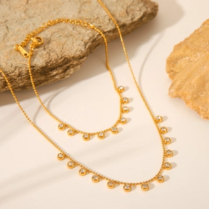 Double layered gold beaded necklace featuring sparkling round zircon pendant charms