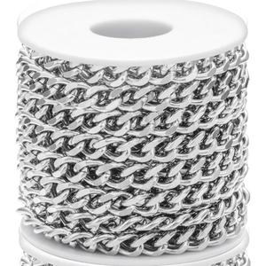 Macro shot of silver stainless steel Cuban link chain wound on a white spool