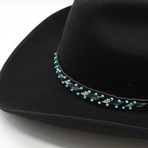 Détail d'un ruban ethnique perlé sur un chapeau de cowboy noir en feutre de laine