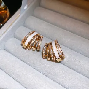Gold plated multi-layer C-shaped earrings with white enamel and cubic zirconia stones