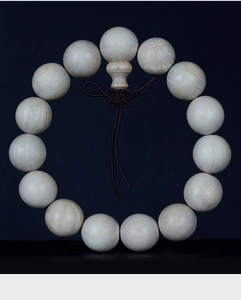 Macro detail of natural camphor wood beads showing authentic texture and Buddhist knot