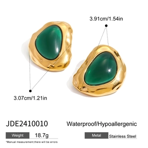 Detailed view of hammered gold stainless steel earrings with emerald green resin inlay