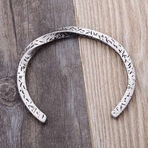 Detailed top view of a vintage silver-finish twisted cuff bracelet with engraved texture