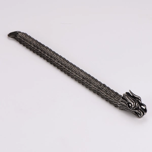 Detail of vintage silver dragon scale bracelet with intricate metal textures and patterns