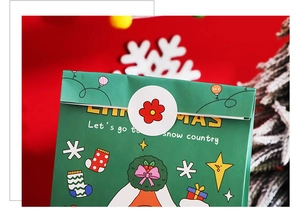 Détail du sac cadeau de Noël vert orné de flocons de neige et d'une couronne festive