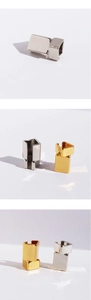 Macro detail of futuristic geometric ear cuff in polished gold and silver finishes
