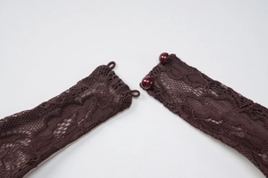 Detail of dark brown floral lace dress featuring delicate double pearl button closure