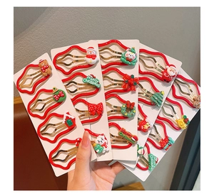 Detailed view of red Christmas hair clips featuring Santa, snowman and reindeer designs