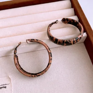 Vintage leopard print hoop earrings with brown pattern on beige display tray