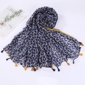 Detail view of navy blue cotton scarf with colorful patterns and yellow tassels