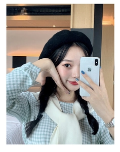 Model selfie showcasing a stylish black wool beret paired with a green checkered shirt