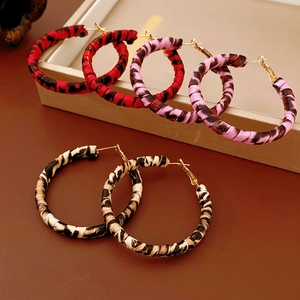Detail von Creolen mit Leopardenmuster in Rot, Rosa und Beige mit goldenen Metallteilen