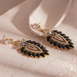 Detailed view of vintage floral earrings with black crystals on textured stone base