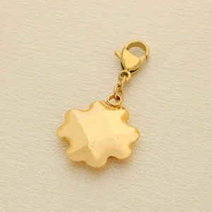 Detail of a wave-shaped gold star pendant with a lobster clasp and polished finish
