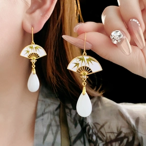 Detail of fan-shaped earring with green bamboo patterns and a white teardrop bead