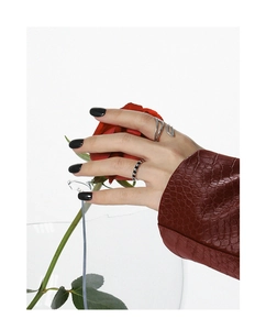 Close-up of minimalist silver rings worn by model holding a red rose with black nail polish