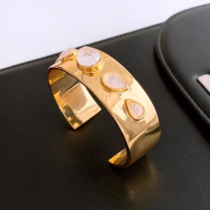Detail of wide 18K gold-plated cuff featuring four pink teardrop-shaped gemstones