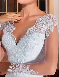 Gros plan d'une élégante robe de mariée avec col en V profond et broderies de dentelle fines