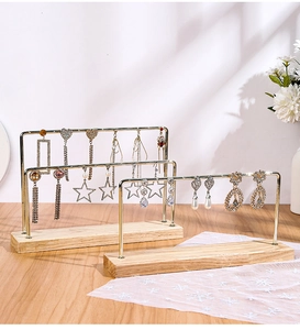 Detail of wooden base jewelry stands with gold metal hangers for earring display