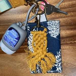Detail of yellow woven cotton tassel keychain with dark blue patterned canvas card holder