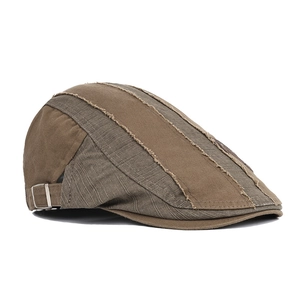 Detail view of coffee and dark grey beret cap with raw edge stitching and side metal buckle